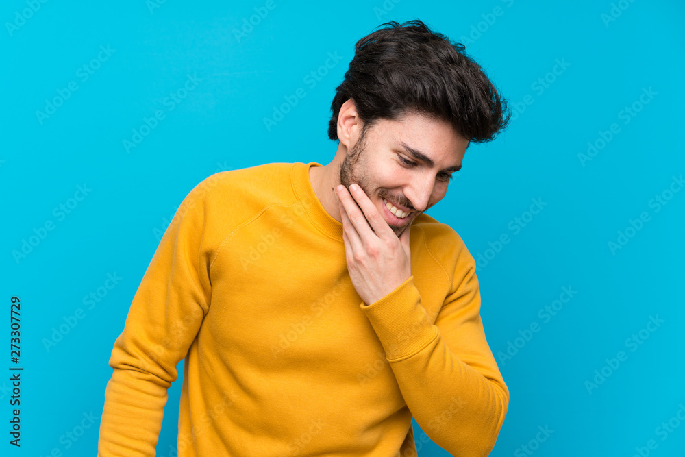 Handsome over isolated blue wall smiling a lot Handsome over isolated blue wall smiling a lot