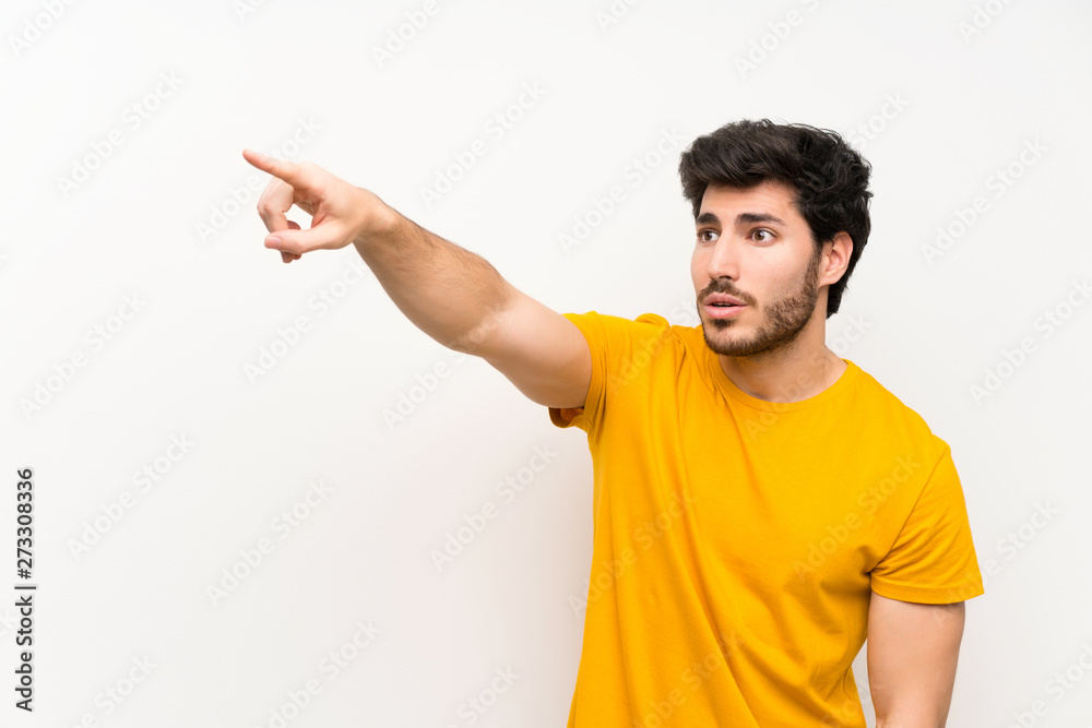 Handsome over isolated white wall pointing away Handsome over isolated white wall pointing away