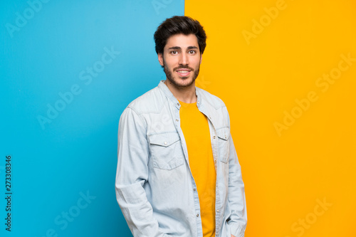 Handsome over isolated colorful background laughing