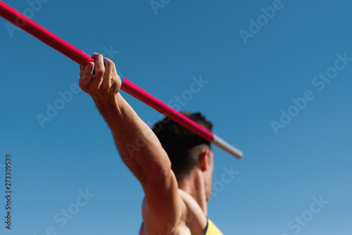 Athlete about to throw a javelin in the stadium photo