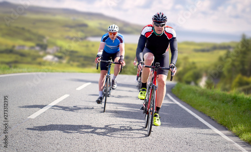 Fototapeta Naklejka Na Ścianę i Meble -  Cyclists out racing along country lanes near the coast in the United Kingdom