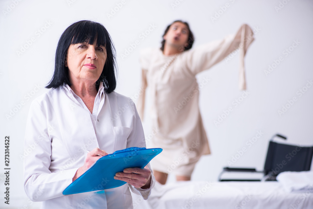 Old female psychiatrist visiting young male patient Old female psychiatrist visiting young male patient