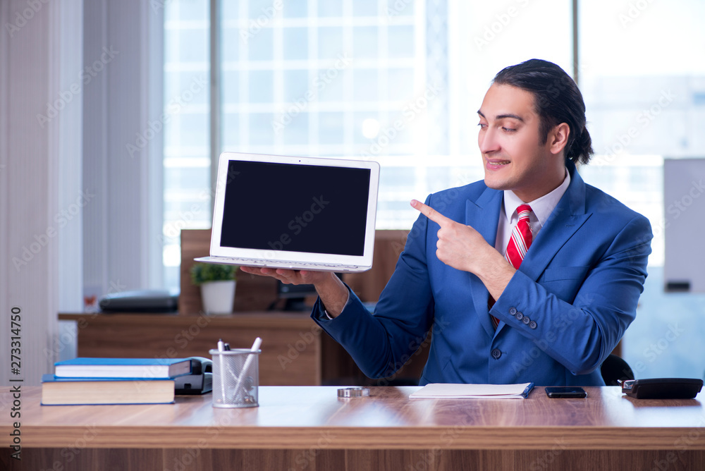 Young handsome businessman sitting in the office 