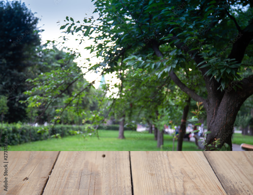 Blurred background of forest park garden with wooden table