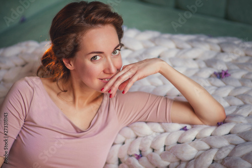 Pregnant happy Woman touching her belly. Pregnant middle aged mother portrait, caressing her belly and smiling close-up. Healthy Pregnancy concept, brunette expectant female on blue background photo