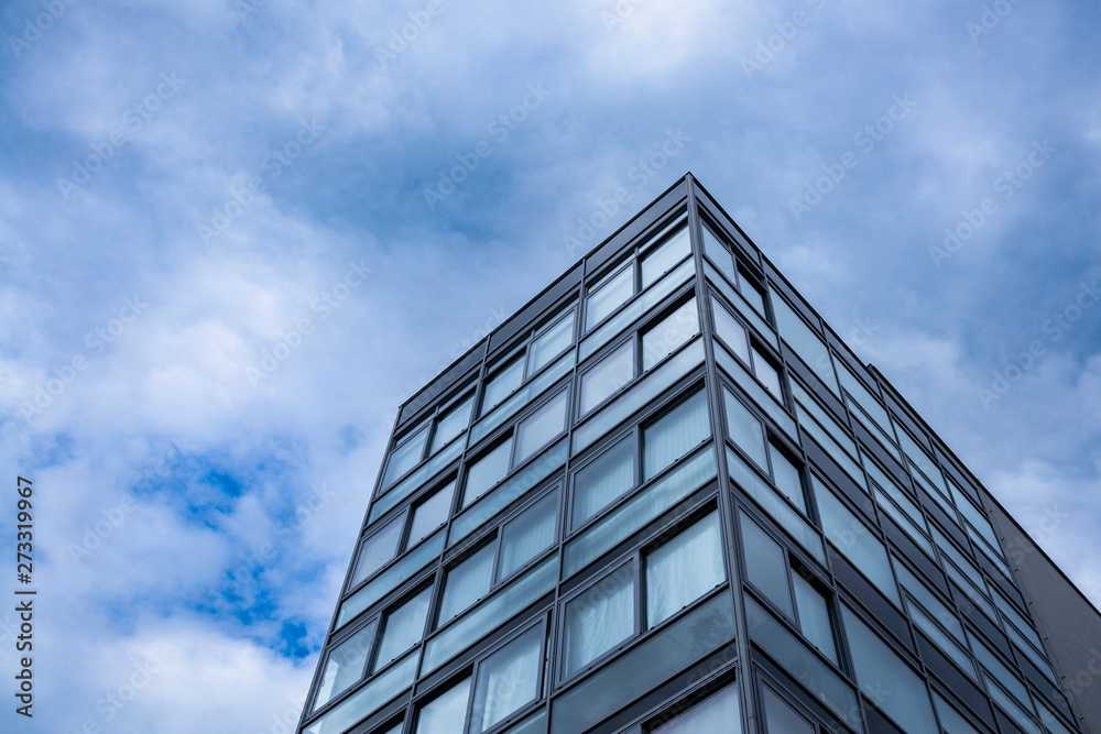 Modern glass office building top tip view from the bottom ground. Sky with clouds on background. Free space for text Modern glass office building top tip view from the bottom ground. Sky with clouds on background. Free space for text