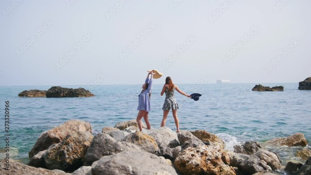 Two attractive women walk along the stony shore in Sorrento and rejoice Two attractive women walk along the stony shore in Sorrento and rejoice