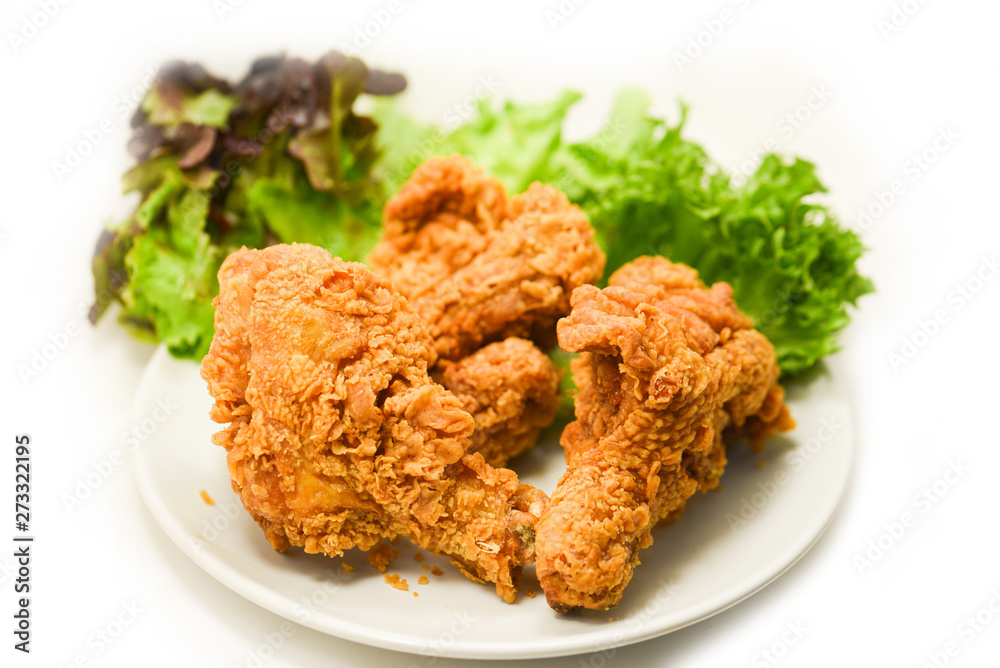 Fried chicken crispy on plate with salad lettuce on white Fried chicken crispy on plate with salad lettuce on white
