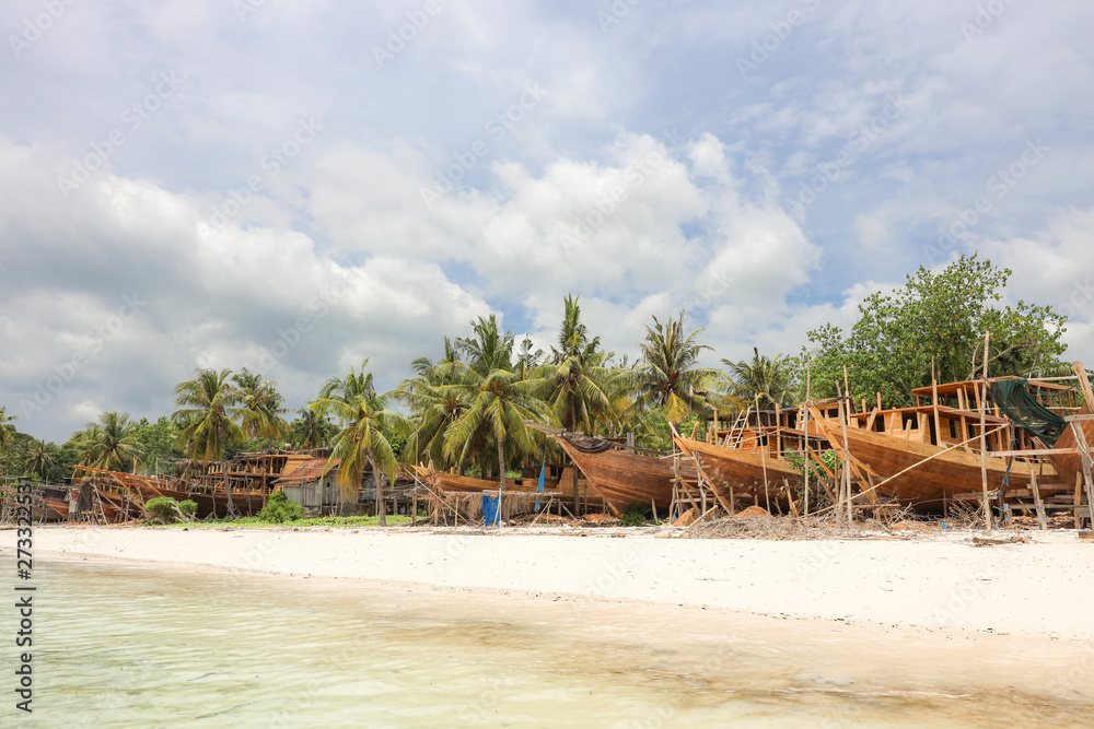 Obraz premium habor contructing wooden boads between palm trees at the beach