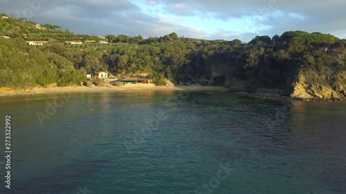 Aerial Drone Shot Flying Away from Spiaggia Zuccale Beach, Elba, Italy on a Calm Sunset Evening photo