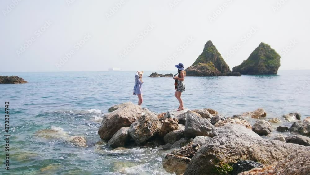 Two attractive women on the beach in Sorrento, one of them playing the guitar and dancing Two attractive women on the beach in Sorrento, one of them playing the guitar and dancing