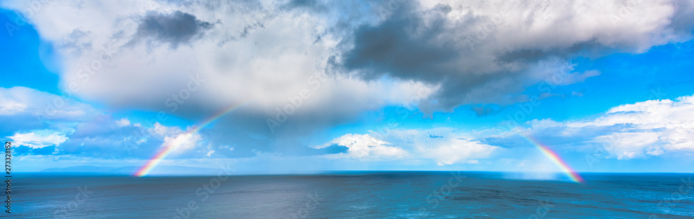 Rainbow against blue sky, ocean and clouds, Northern Ireland