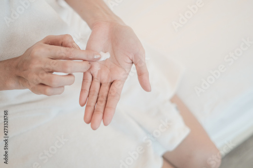 Woman applying moisturizing cream/lotion on hands, Top View, beauty concept.