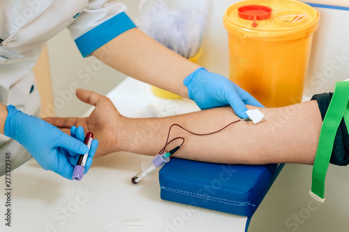 Biochemical analysis of blood in men. HIV test for a young guy. A blood sample from a vein for the test. The man in the doctor's office photo