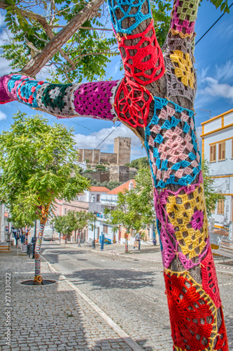 Trees decorated with colorful crochet patchwork on a holiday in the town of Mertola, a very beautiful city in the Portuguese Alentejo area