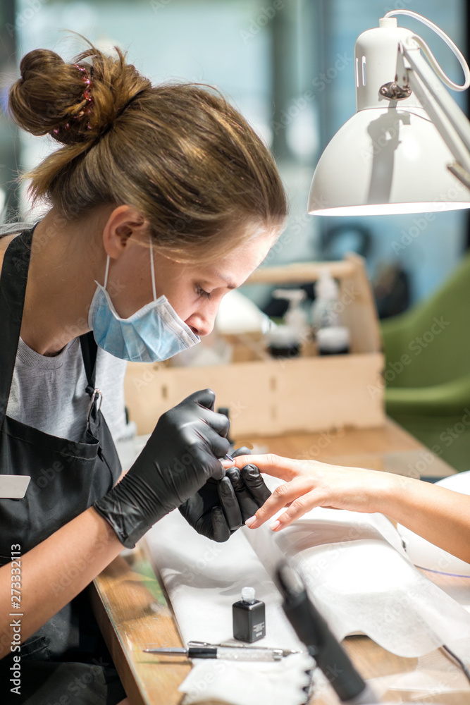 The process of manicure in a beauty salon, close-up. The process of manicure in a beauty salon, close-up.