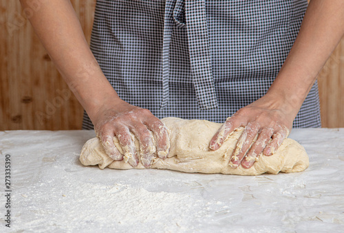 Mistress kneads the dough in the kitchen © schankz