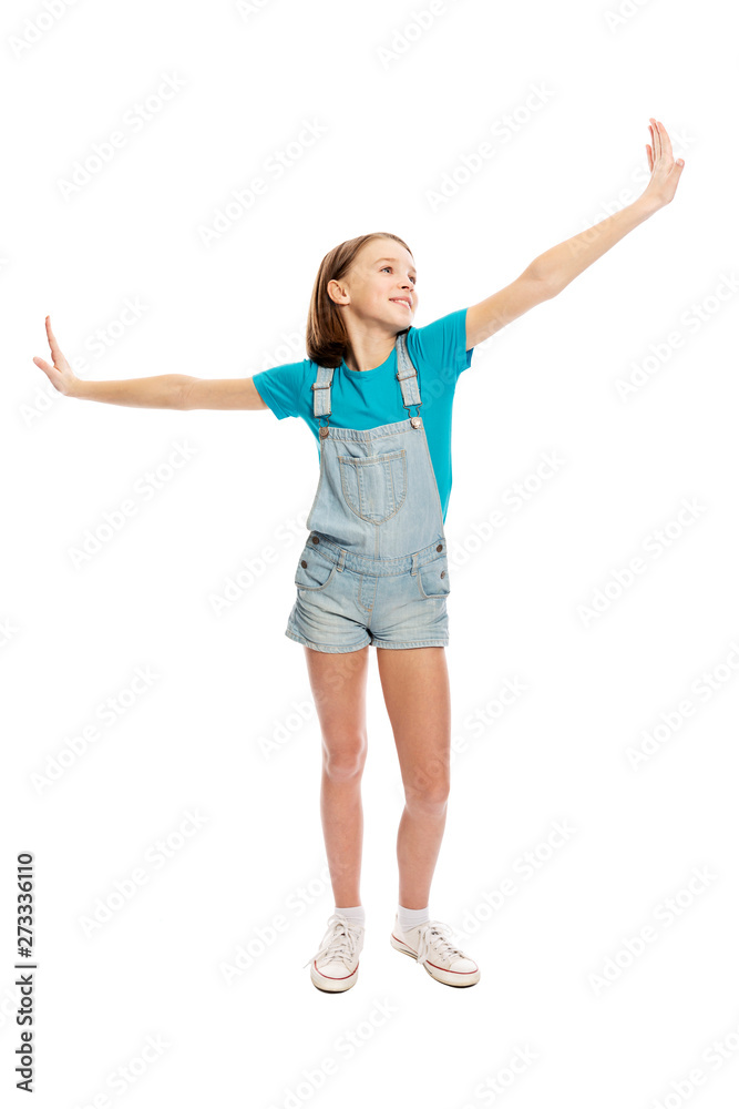 Teen girl in denim overalls in a flying pose, full height. Isolated on a white background. Vertical. Teen girl in denim overalls in a flying pose, full height. Isolated on a white background. Vertical.