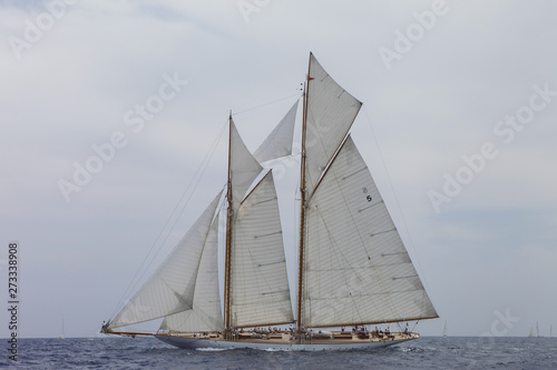 Nautical sports in the ocean. Vintage yachts race in Barcelona. Old ships and boats in the sea. Regatta in mediterranean sea. Sails, mast, sheet, canvas in the sky. Holidays in spain. 