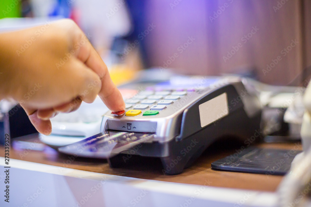 Fototapeta premium Hand put credit card In slot and press the button of credit card reader.