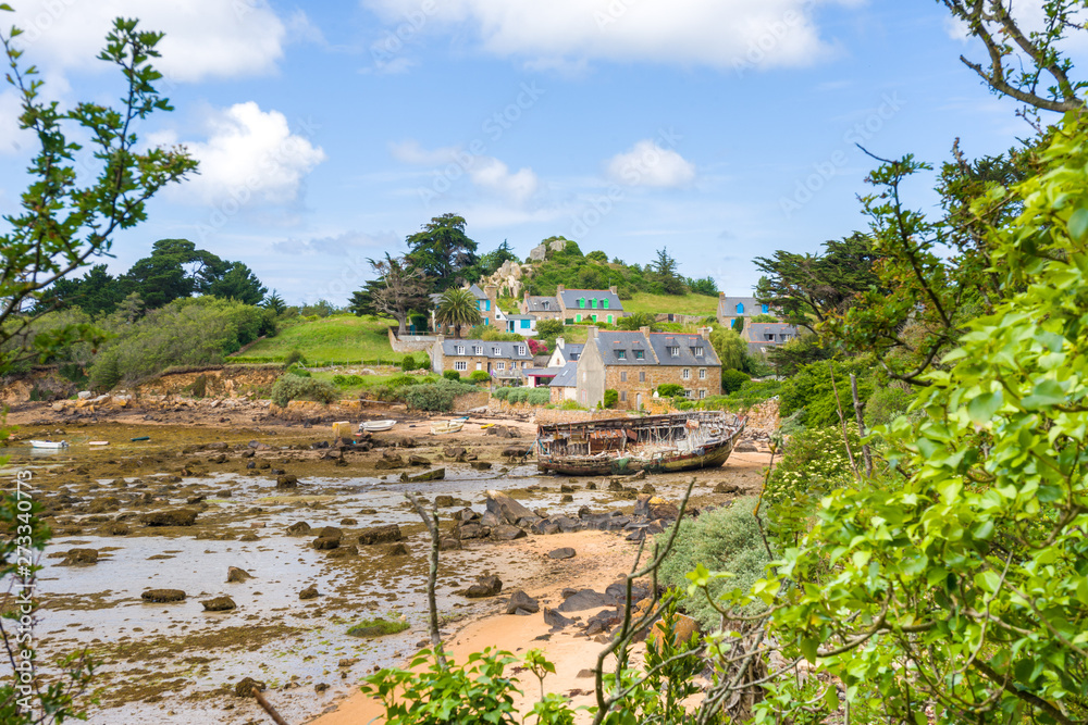Fototapeta premium île de bréhat, ses maisons en pierre, plage à marées basse et un bateau échoué, côtes d'amor, Bretagne