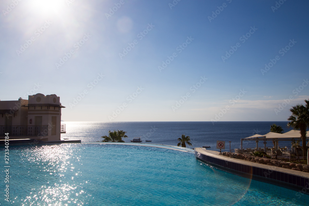 SHARM EL SHEIKH, EGYPT - March 18, 2019: Building, Concord Hotel. View of the beautiful pool with palm trees. Background for tourism and travel. Clear water and blue sky.