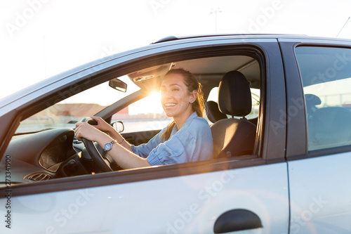 Happy woman driving a car and smiling