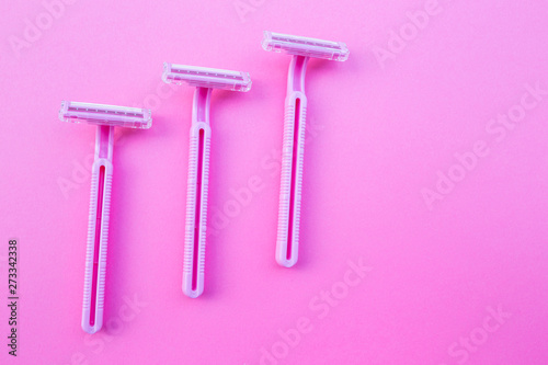 Three women's razors pink color on an isolated pink background.