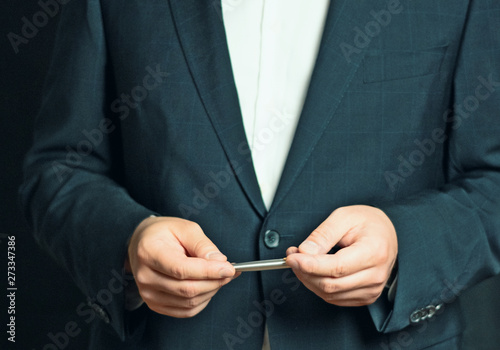 Businessman is holding a presentation or explaining, gesturing with a silver pen in his hand
