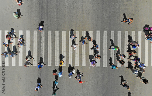 Aerial. People crowd on pedestrian crosswalk. Top view.