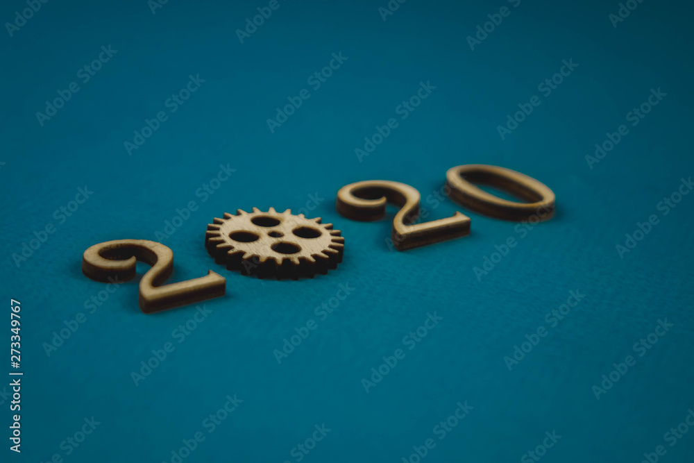 2020 number from wooden numbers on a blue background with scattered stars gears and flags around