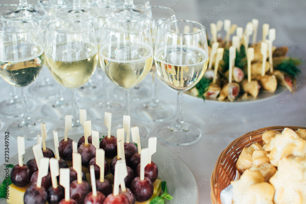 Catering services background with snacks,fruits canape and glasses of champagne or wine on bartender counter in restaurant