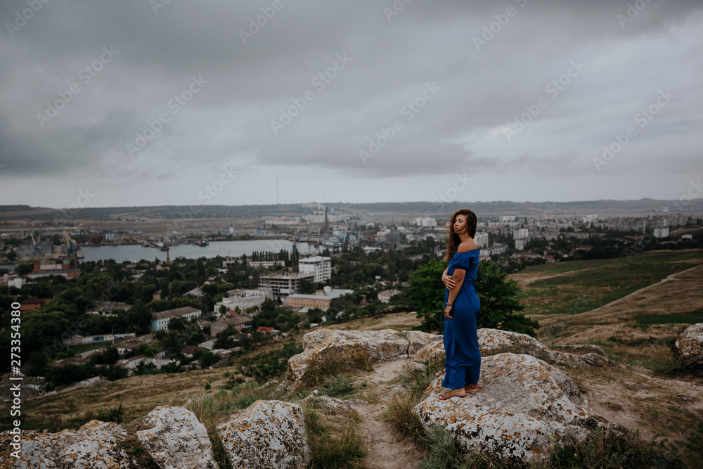 Fototapeta premium Beautiful tanned girl in long blue dress