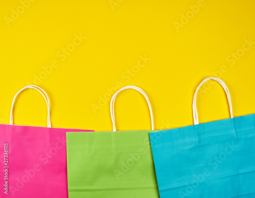 rectangular multi-colored paper shopping bags with white handles