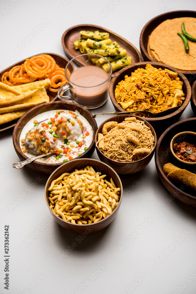 Group of Gujarati snacks like jalebi-fafda, thepla, khaman dhokla, aloo bhujiya, khandvi,khakra, dahi vada, gathiya with hot tea