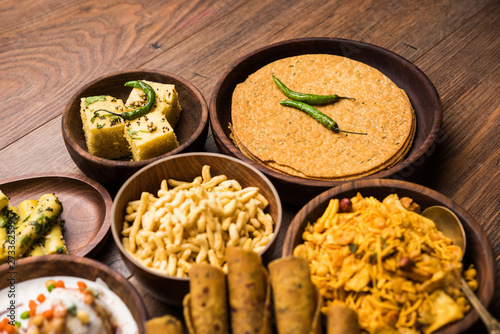 Group of Gujarati snacks like jalebi-fafda, thepla, khaman dhokla, aloo bhujiya, khandvi,khakra, dahi vada, gathiya with hot tea
