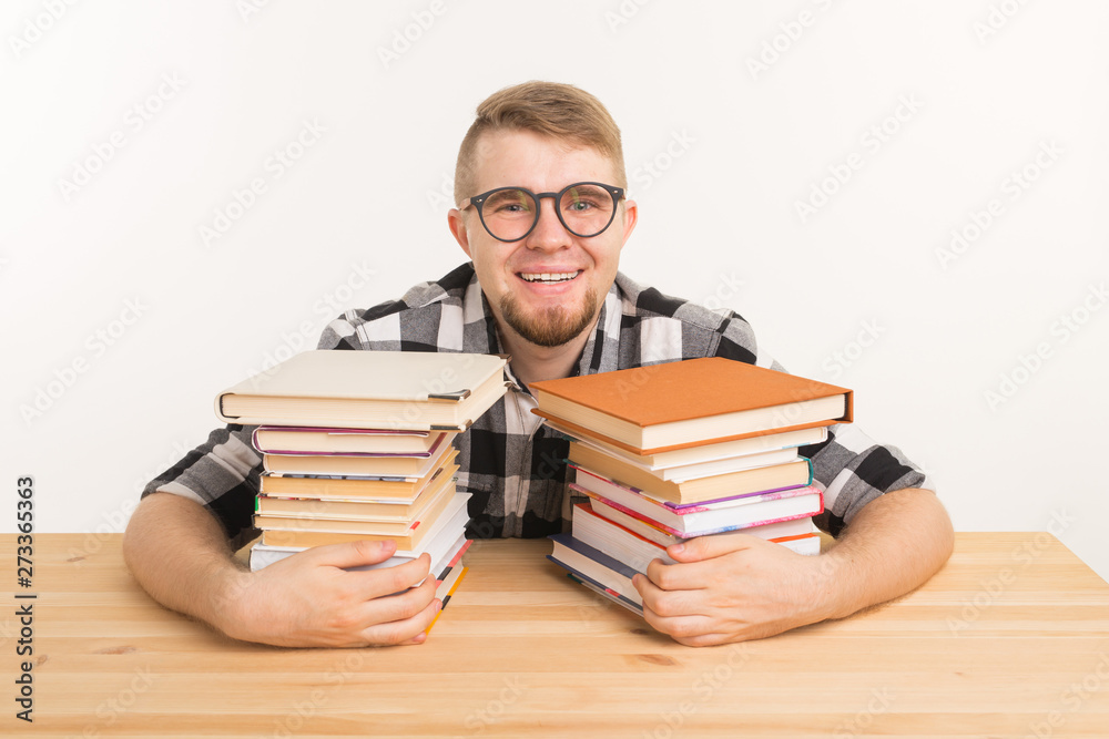 People, knowledge and education concept - Guy sitting hugging a book at the wooden table People, knowledge and education concept - Guy sitting hugging a book at the wooden table