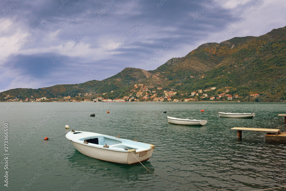 Cloudy autumn landscape - mountains, sea, and fishing boats on the water. Montenegro, Adriatic Sea, view of  Bay of Kotor  near Verige Strait