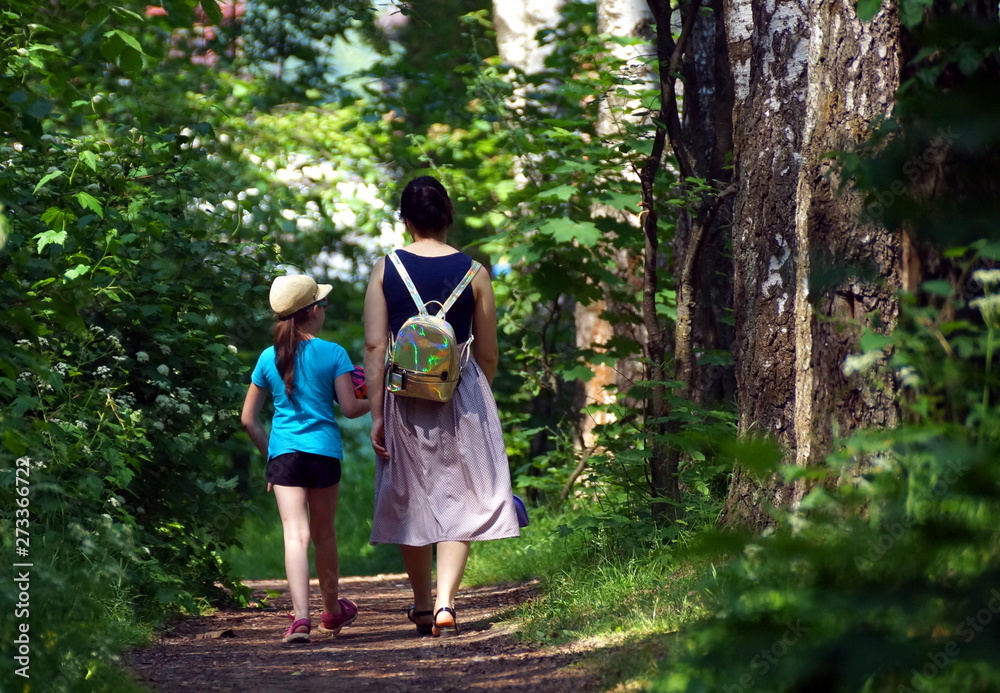mother and daughter walking in the park mother and daughter walking in the park