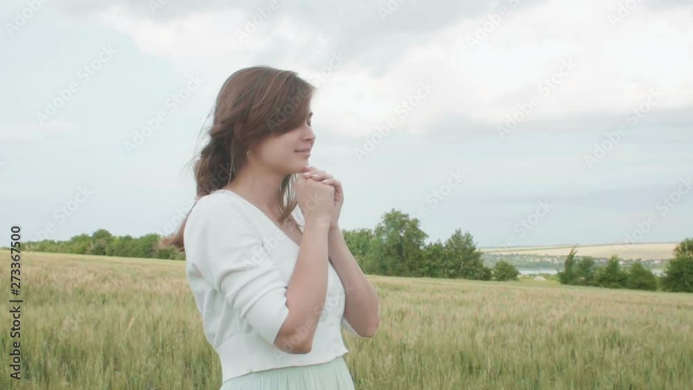 a young girl praying in a wheat field, a woman among ears of corn enjoying nature and thanking God, a concept of religion and faith a young girl praying in a wheat field, a woman among ears of corn enjoying nature and thanking God, a concept of religion and faith