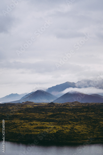 Beautiful green Icelandic landscapes with misty mountains on the horizon