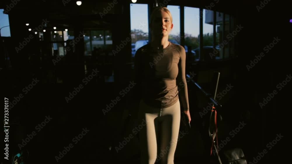 pretty blonde woman in trendy sportswear performs box step up in professional gym crossfit zone at sunset light closeup pretty blonde woman in trendy sportswear performs box step up in professional gym crossfit zone at sunset light closeup