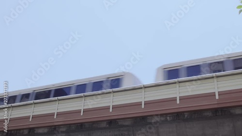 Low angle view as a city passenger train passes left to right on an elevated track system.
