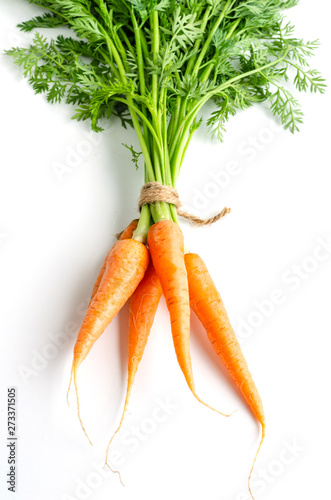 Fresh carrots with green foliage on white background.