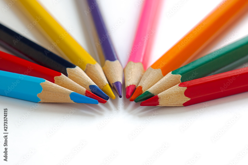 bright pencils lie in a semicircle close to each other, multi-colored sharp slate pencils, minimalism