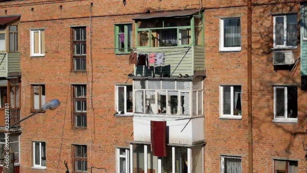 Windows and balconies of the old brick apartment building of the USSR. Khrushev project House 1961