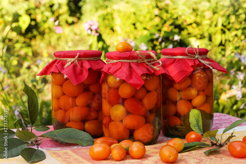 Marinated cherry tomatoes in jars on a table in the garden