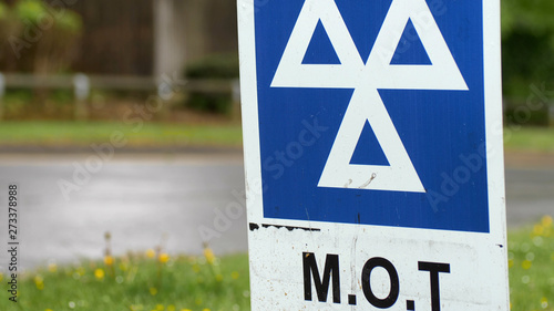 Blue MOT service sign on british road on cloudy rainy day photo