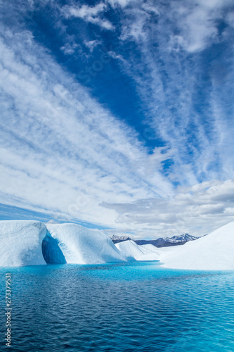 Clouds over deep blue glacial lake and ice cave on the Matanuska Glacier in Alaska photo