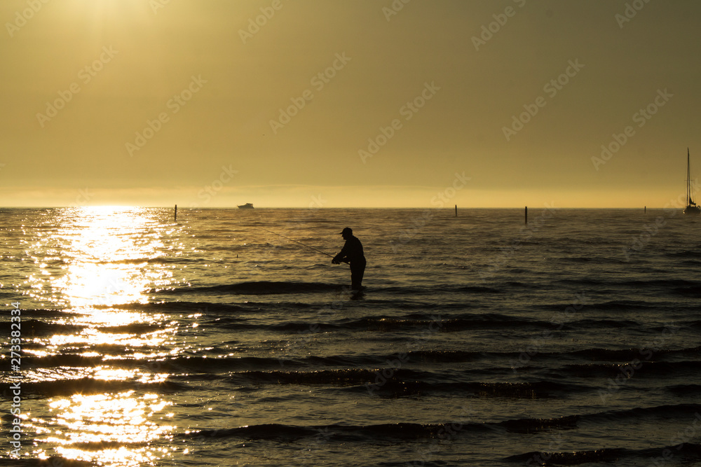 silhouette of a fisherman with a fishing rod in the sea silhouette of a fisherman with a fishing rod in the sea